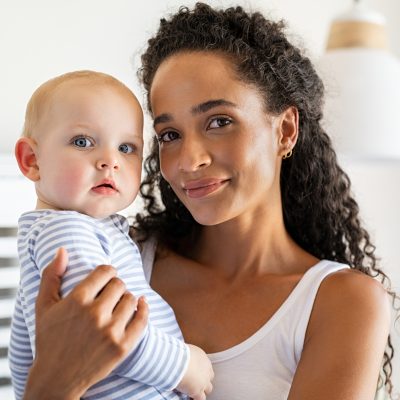 Smiling,African,Mother,Holding,Adopted,Baby,At,Home.,Portrait,Of